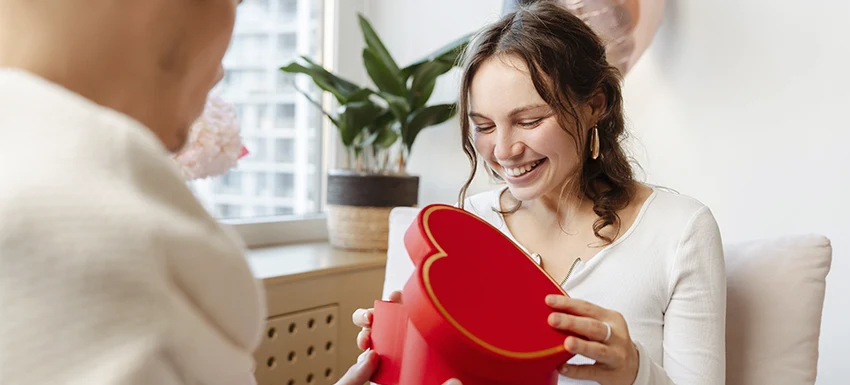 persona abriendo una caja de regalo de san valentín con forma de corazón